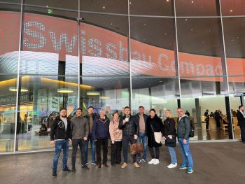 ludzie pozujący do zdjęcia na tle swissbau compact