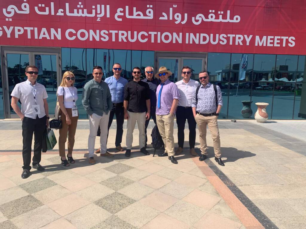 zespół pozujący do zdjęcia na tle budynku